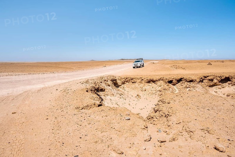 Offroad Car drives trough Rocky landscape, Moon Valley, Namib-Naukluft Park, Namib Desert, Namibia