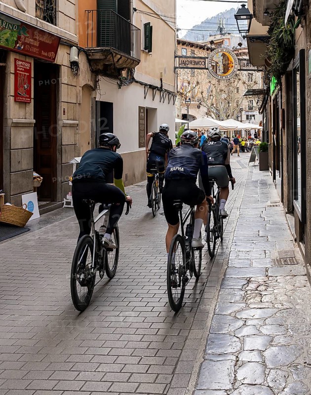 Group of racing cyclists in a narrow alley, Soller, Majorca, Balearic Islands
