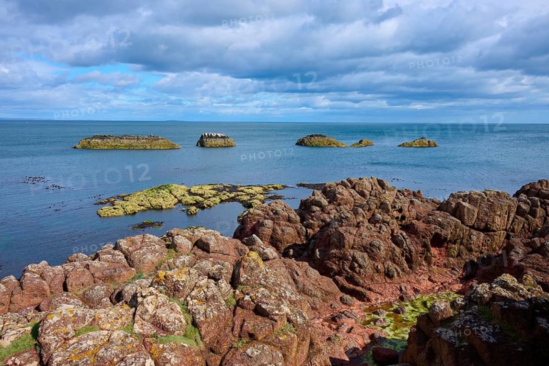 Rocks and islands rising from the sea under a dramatically cloudy sky, Dunbar, East Lothian, Scotland, United Kingdom, United Kingdom