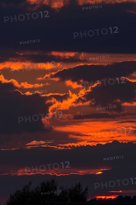 Red sun behind clouds in the evening sky, Mecklenburg-Vorpommern, Germany