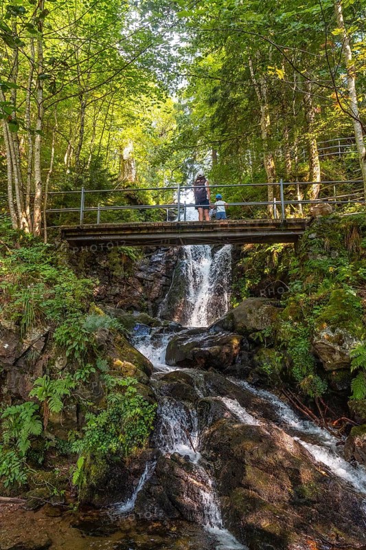A mother with her child on a bridge at the Todtnau waterfall in the Black Forest in Germany