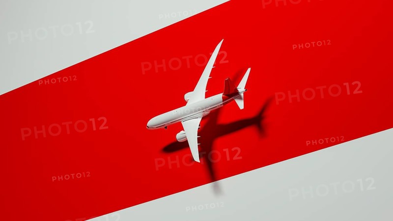 A sleek commercial airplane appears to soar gracefully against a striking red background. This design showcases a sense of travel and adventure