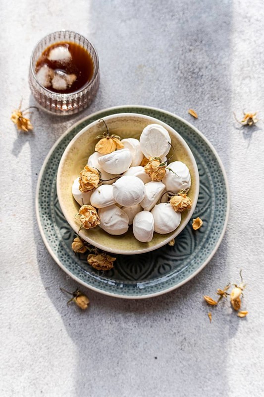 Homemade mini marshmallows filled with rose jam and elegantly paired with a glass of iced coffee liqueur Perfect for a sweet treat