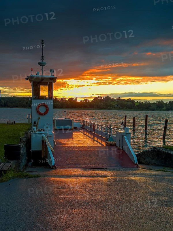 Sunset over the Chiemsee, in front the Chiemsee ferry, view from the island Frauenchiemsee, Bavaria, Germany