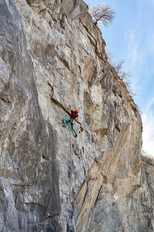 Climber climbs on a rocky wall. Extreme sport climbing