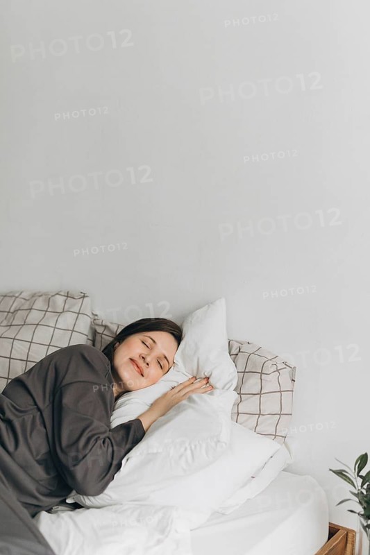 A serene scene of a woman sleeping peacefully, emphasizing the importance of restful sleep in maintaining optimal health and wellness