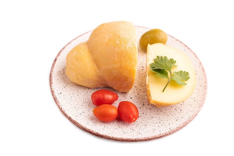 Smoked Mozzarella cheese, with tomatoes and olives isolated on white background, side view, copy space