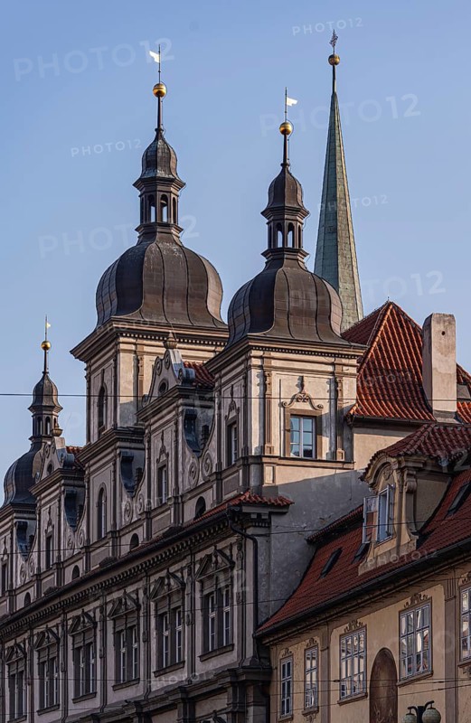 A intricate architectural details of Prague's historic buildings, showcasing classic spires and ornate facades under a clear sky, epitomizing Europe's cultural heritage
