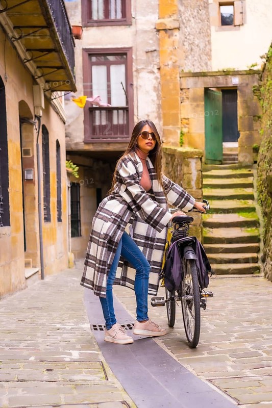 Latin woman doing bicycle tourism in the city. Ecological tourism lifestyle