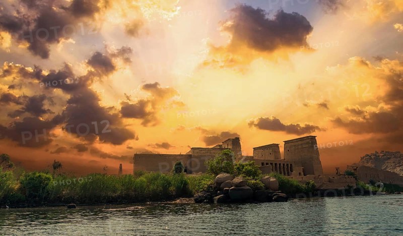 Incredible orange sunrise at the temple of Philae, a Greco-Roman construction seen from the Nile river, a temple dedicated to Isis, goddess of love. Aswan. Egyptian