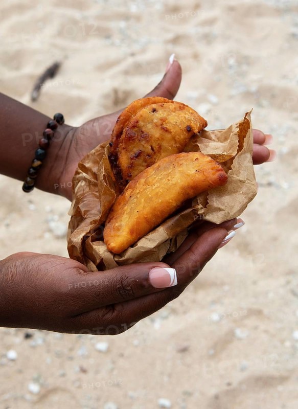 Women's hands holding samoussas or deep-fried dumplings, Mauritius