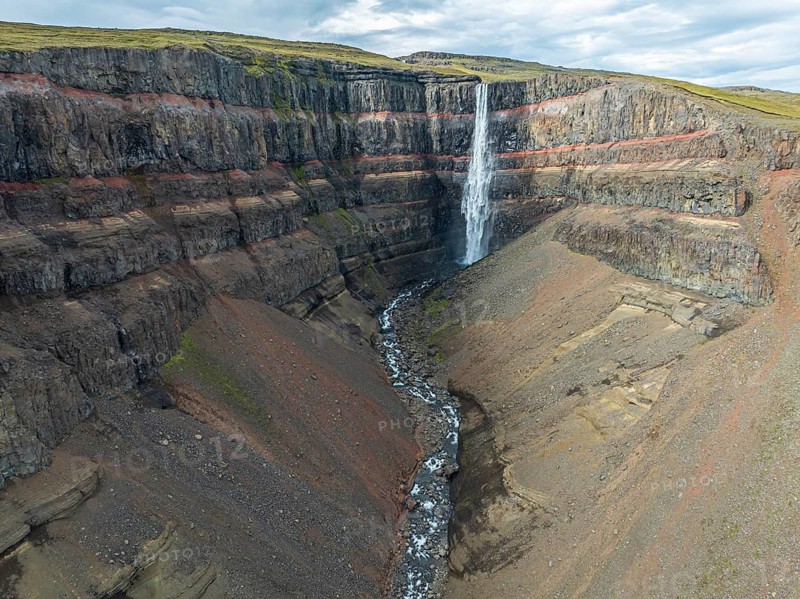 Waterfall Hengifoss, basaltic layers interwoven with red sedimentary layers, aerial view, Iceland