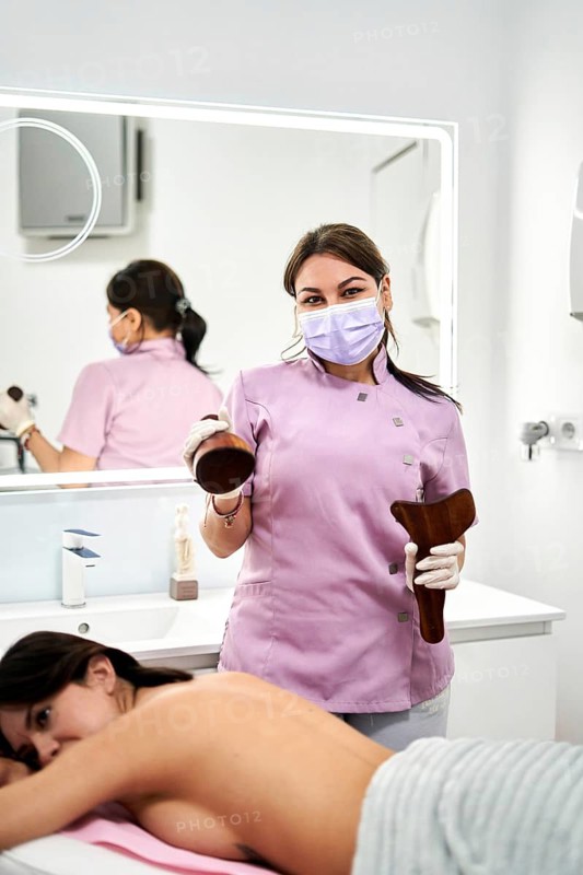 Expert therapist performs a massage treatment in a modern aesthetic medicine clinic. The calming atmosphere enhances relaxation for the client receiving care