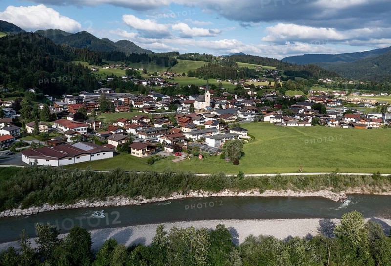 Drone shot, view of the village with parish church, Kössen, Leukental, Tyrol, Austria