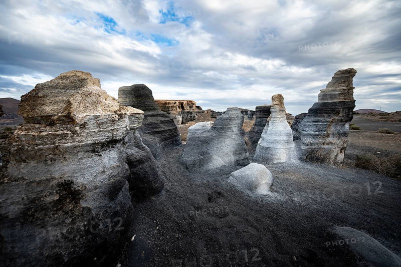 Eroded rock formations, volcanic landscape with dramatic cloudy skies, Ciudad Estratificada or Los Roferos, Antigua Rofera de Teseguite, Lanzarote, Canary Islands, Spain