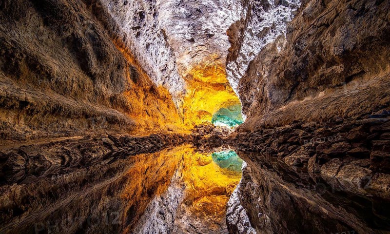 Lava tunnel, illuminated lava cave with perfect reflection in an underground lake, Cueva de los Verdes, Lanzarote, Canary Islands, Spain