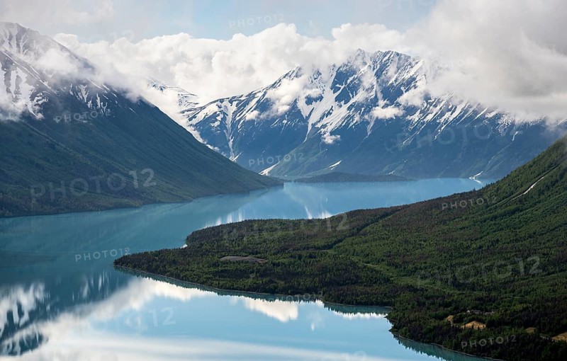 View of snowy mountains in spring and turquoise Kenai Lake with reflection, Slaughter Ridge Trail, Cooper Landing, Kenai Peninsula, Alaska, USA