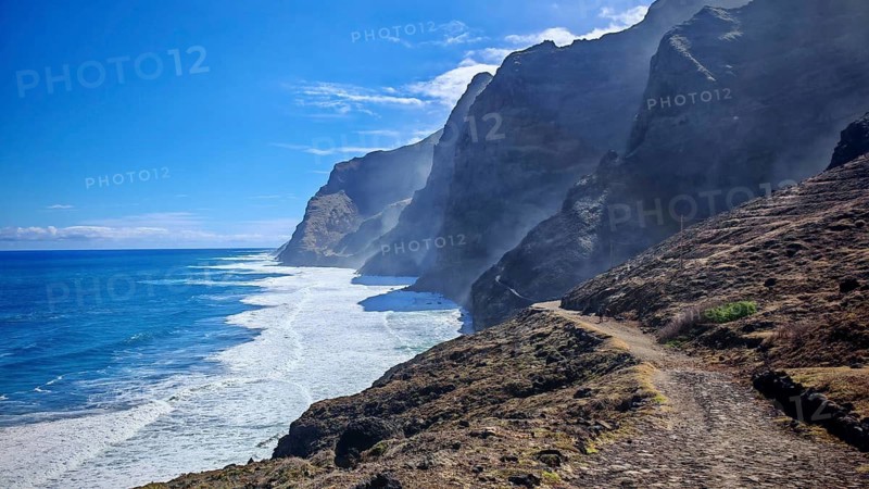 Dramatic coastline with steep cliffs and a trail along the ocean, A hiker in the distance, hiking from Cruzinha to Ponta do Sol, hiking, Santo Antao, Cabo Verde, Cape Verde, Cape Verde