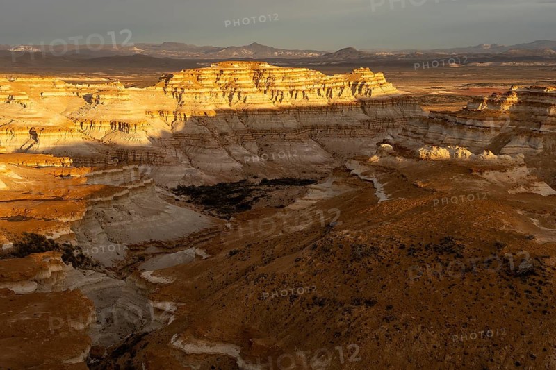Eroded sedimentary rock formations with horizontal stratification in evening light, gorges and table mountains in barren steppe landscape, Santa Cruz province, Patagonia, Argentina