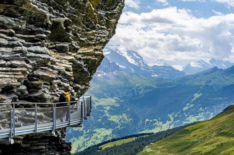 Young man on First Cliff Walk, metal trail on a rocky outcrop, Grindelwald First, in front of impressive mountain scenery, Bernese Alps, Bernese Oberland, Switzerland