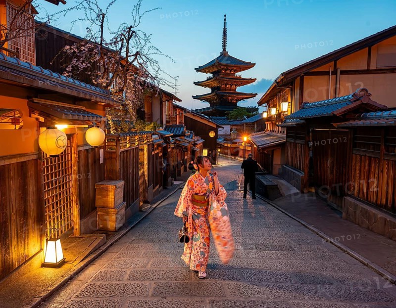Japanese woman in kimono in an alley, Yasaka dori historic alleyway in the old town with traditional Japanese houses, five-story Yasaka Pagoda of the Buddhist Hokanji Temple in the back, evening mood, blue hour, Higashiyama, Kyoto, Japan