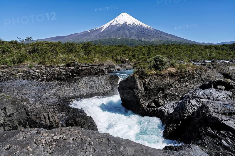 Osorno volcano with snow-capped summit, in the foreground the Saltos del Petrohué with turquoise water between black lava rocks, Vicente Pérez Rosales National Park, Los Lagos Region, Chile