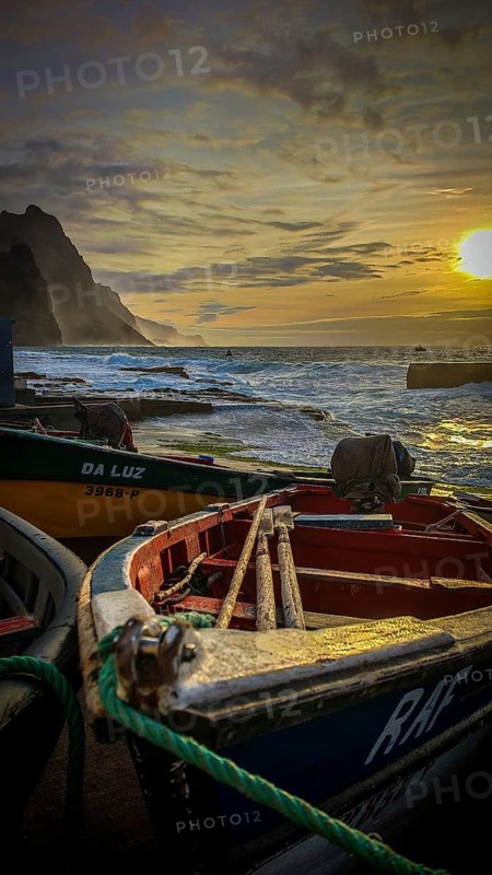 Colorful fishing boats on the shore with ropes and setting sun over the sea, dramatic coastal scenery, mountains in the background, romantic harbor scene in the evening light, Ponta do Sol, Santo Antao, Cabo Verde, Cape Verde, Cape Verde