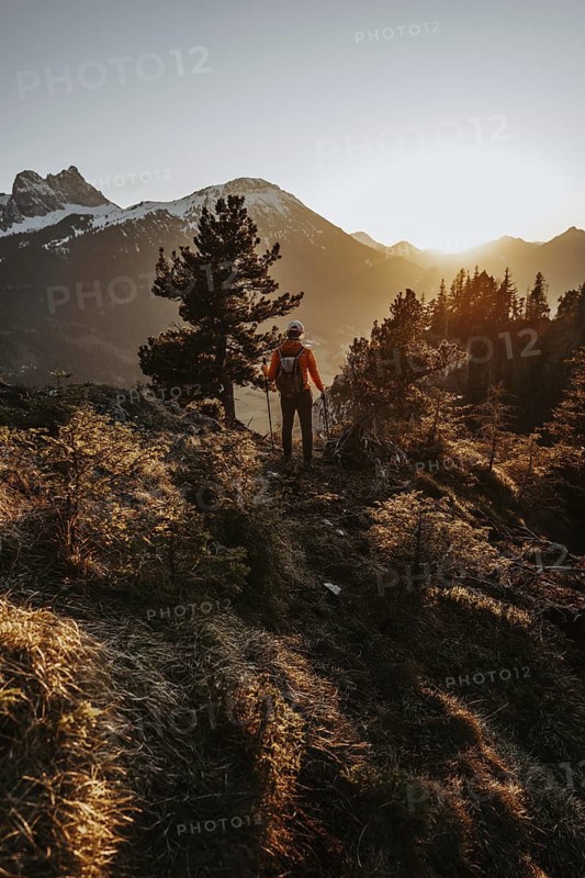 Hiker in the Allgäu at sunset in spring on the Zirmgrat near Pronten in the Allgäu