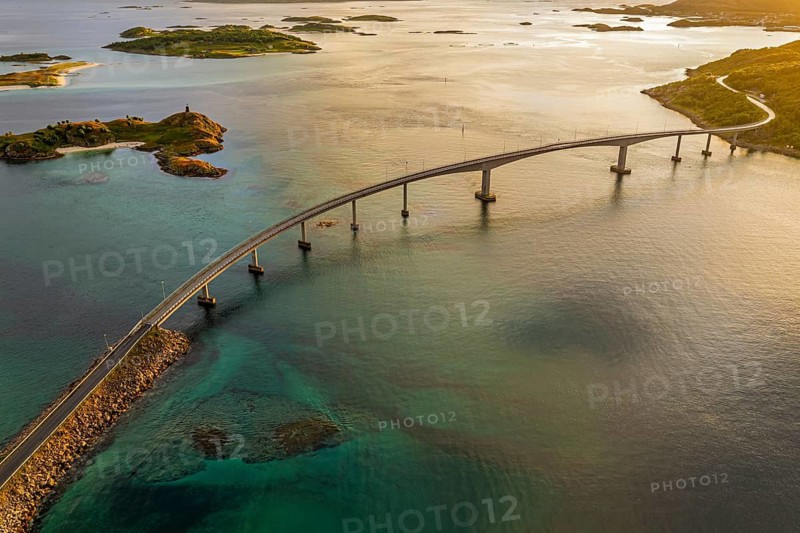 Sommaroy Bridge connecting Kvaloya Island to Sommaroy Island, warm light at sunset, aerial view, Norway