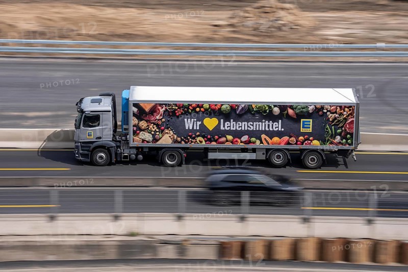 Freight truck for food logistics, on the motorway, supermarket chain EDEKA