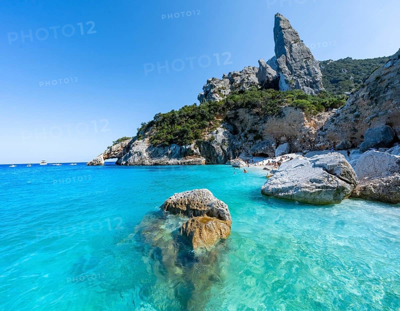 Light blue clear sea on a dream beach on Cala Goloritzé, picturesque rocky coast, steep coast with rock pin L'Aguglia, Golfo di Orosei, Baunei, Sardinia, Italy