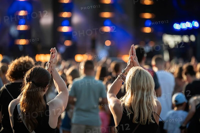 Two women having fun during a concert in front of the stage in Wroclaw, Poland