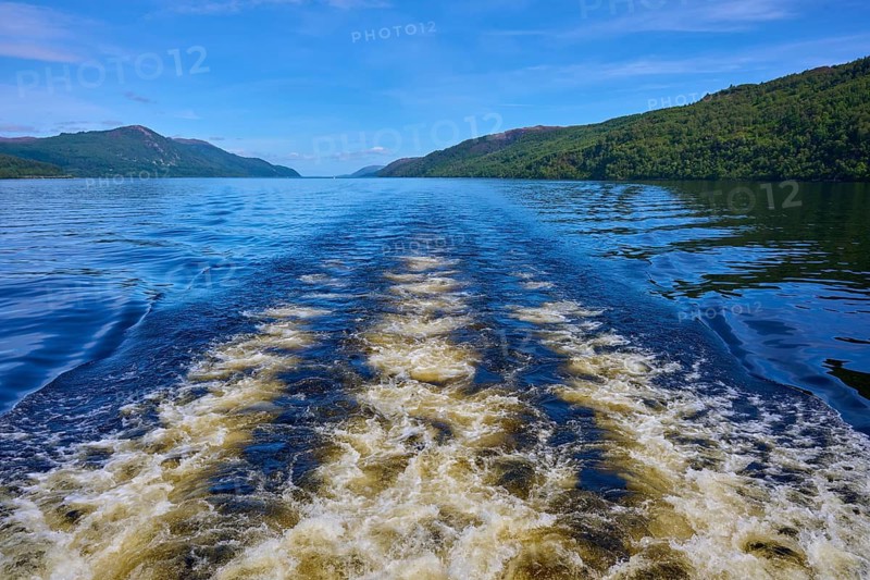 Wave movement on a river surrounded by rolling landscape and blue sky, Fort Augustus, Loch Ness, Scotland, United Kingdom, Great Britain