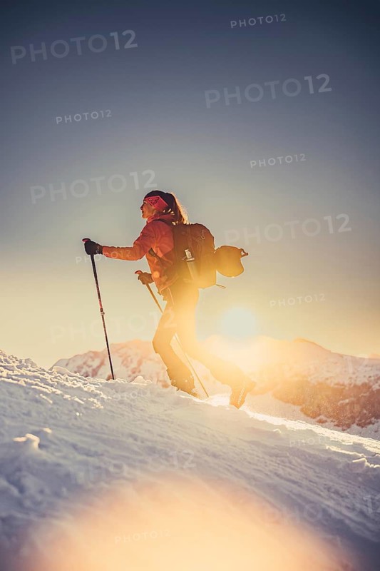 A woman's ski tour at sunrise on the Tegelberg in the Allgäu in the Ammergebirge, Bavaria, Germany