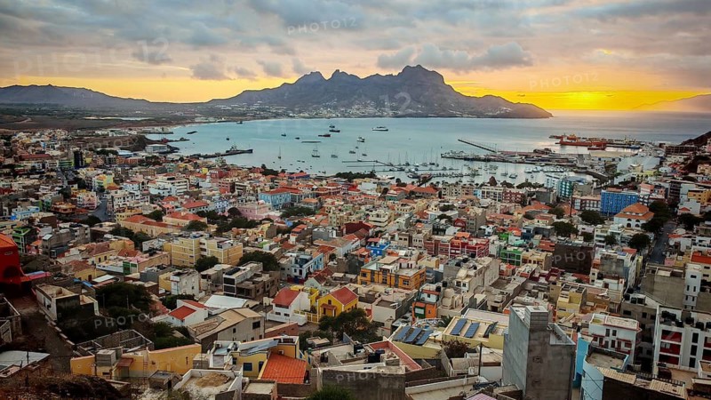 Panoramic view from above of coastal town of Mindelo at sunset with colorful buildings, harbor and mountains, Mindelo, Sao Vicente, Cabo Verde, Cape Verde, Cape Verde