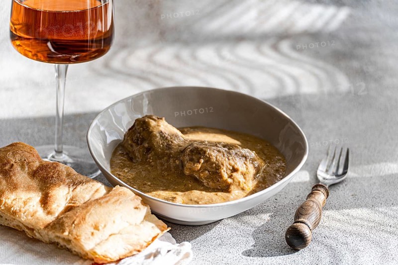 Enjoy a classic Georgian satsivi, tender chicken served in a creamy walnut sauce, accompanied by amber wine and fresh Georgian bread