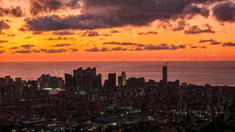 Skyline at sunset with illuminated buildings and deep red sky, Batumi, Georgia