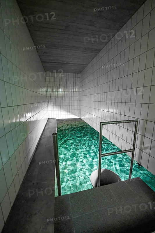 Long swimming pool with green water and white tiles, ENCW Netze Calw waterworks, Calw, Black Forest, Germany