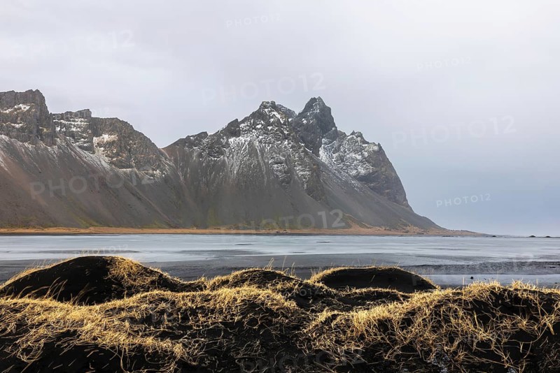 Sand dunes covered with rotten grass, lava sandy beach against mountain backdrop, winter, Stokksnes, Vestrahorn, Klifatindur, Höfn, Iceland, Scandinavia