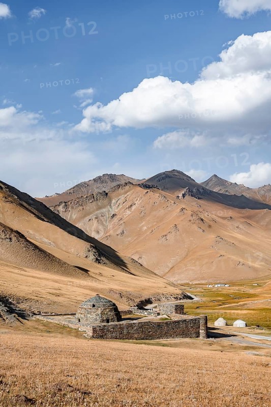 Historic caravanserai Tash Rabat from the 15th century, with yellow hills, Atbashy district in the Naryn region, Kyrgyzstan