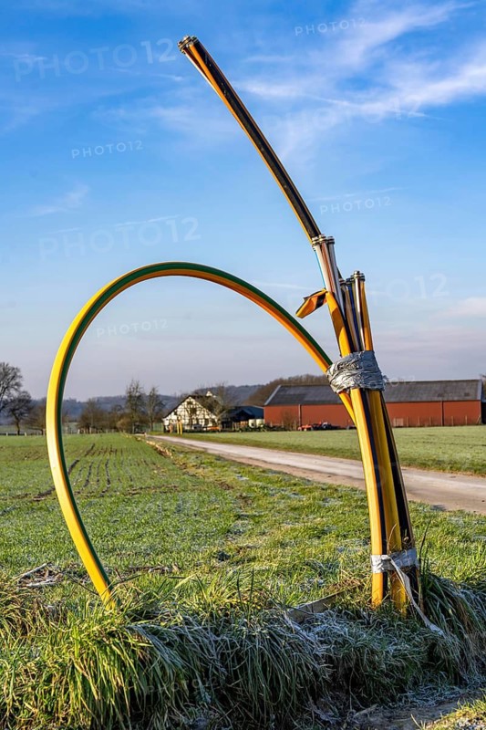 Fibre optic connection, empty conduits protrude from the ground along a dirt track, into which the actual fibre optic cable is later blown and connected to the respective house connection or distributor, provision of fast Internet in rural areas, in the south of Mülheim an der Ruhr, North Rhine-Westphalia, Germany