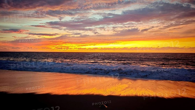 Romantic sunset on the beach, the sea reflecting the warm tones of the evening sky, Tarrafal de Monte Trigo, Santo Antao, Cabo Verde, Cape Verde