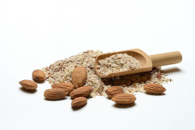 Almonds and ground almonds with wooden scoop, Prunus amygdalus