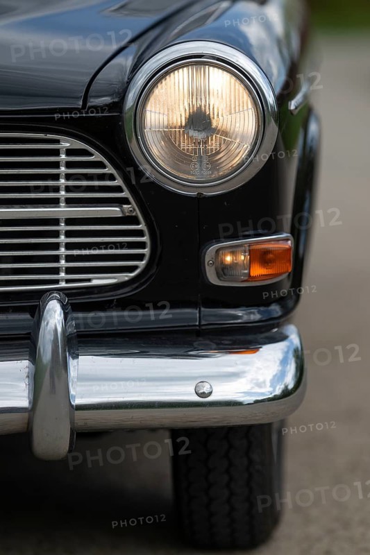 Front round front light and front section with chrome bumper, vintage car, black Volvo Amazon, medium class car from Swedish car manufacturer Volvo, built in 1968