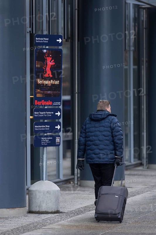 A man with a suitcase passes a signpost to the Berlinale in front of the opening of the 76th Berlinale at the Theater am Potsdamer Platz in Berlin on 11.02.2026. The film festival will take place from February 12-22, 2026