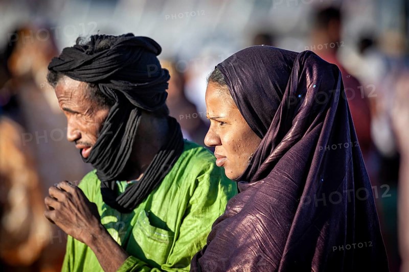 A man and a woman in traditional dress stand in the open air, a couple at the traditional Tuareg festival of Tamanrasset in the Sahara in Algeria
