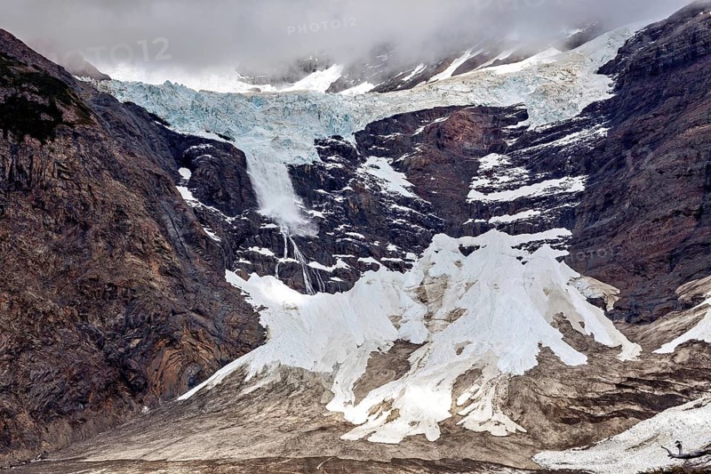 Majestic glacier landscape with rugged rocks and snow under a dramatic cloud cover, The glaciers of the Torres del Paine National Park in Patagonia Chile