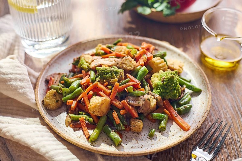 Plate of stir-fried mixed vegetables with green beans, carrots, baby corn, romanesco and mushrooms
