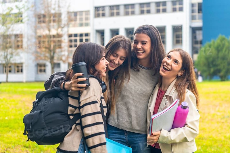 Group of female students enjoying a moment of pure joy and togetherness, sharing laughter while walking on the university campus grounds after classes, embodying friendship and happiness