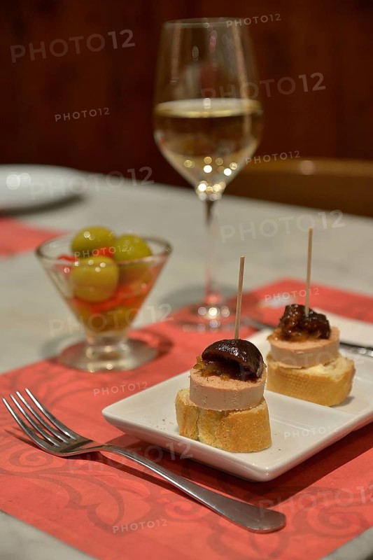 Foie gras with caramelized pumpkin on white bread, green olives, and white wine in a tapas bar, Palma, Mallorca, Balearic Islands, Spain